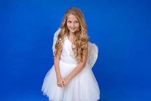 postal para el día de san valentín. niño en vestido blanco largo y con alas de ángel foto