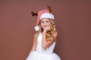 Happy funny child girl in red christmas deer costume smiling looking at camera. photo