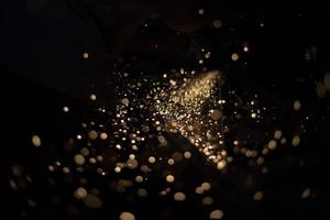 Sparks in dark. Stream of lights on black background. Metal crushing. High temperature. photo