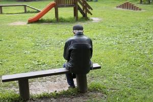 anciano sentado en un banco. persona mayor en el parque. pensionista descansa en la naturaleza. foto