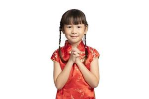chica asiática en cheongsam con gesto de felicitaciones aislado sobre fondo blanco. feliz Año Nuevo Chino. foto
