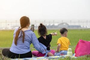 Mother and son watch planes take off and land next to the airport on weekends. rest on vacation photo