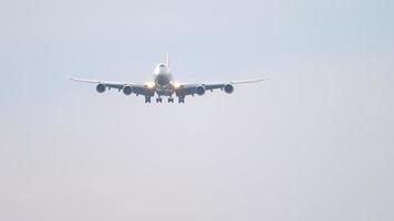 un avion de passagers à quatre moteurs à fuselage large vole au-dessus. avion de passagers à quatre moteurs à corps large vole dans le ciel à la lumière du coucher du soleil video