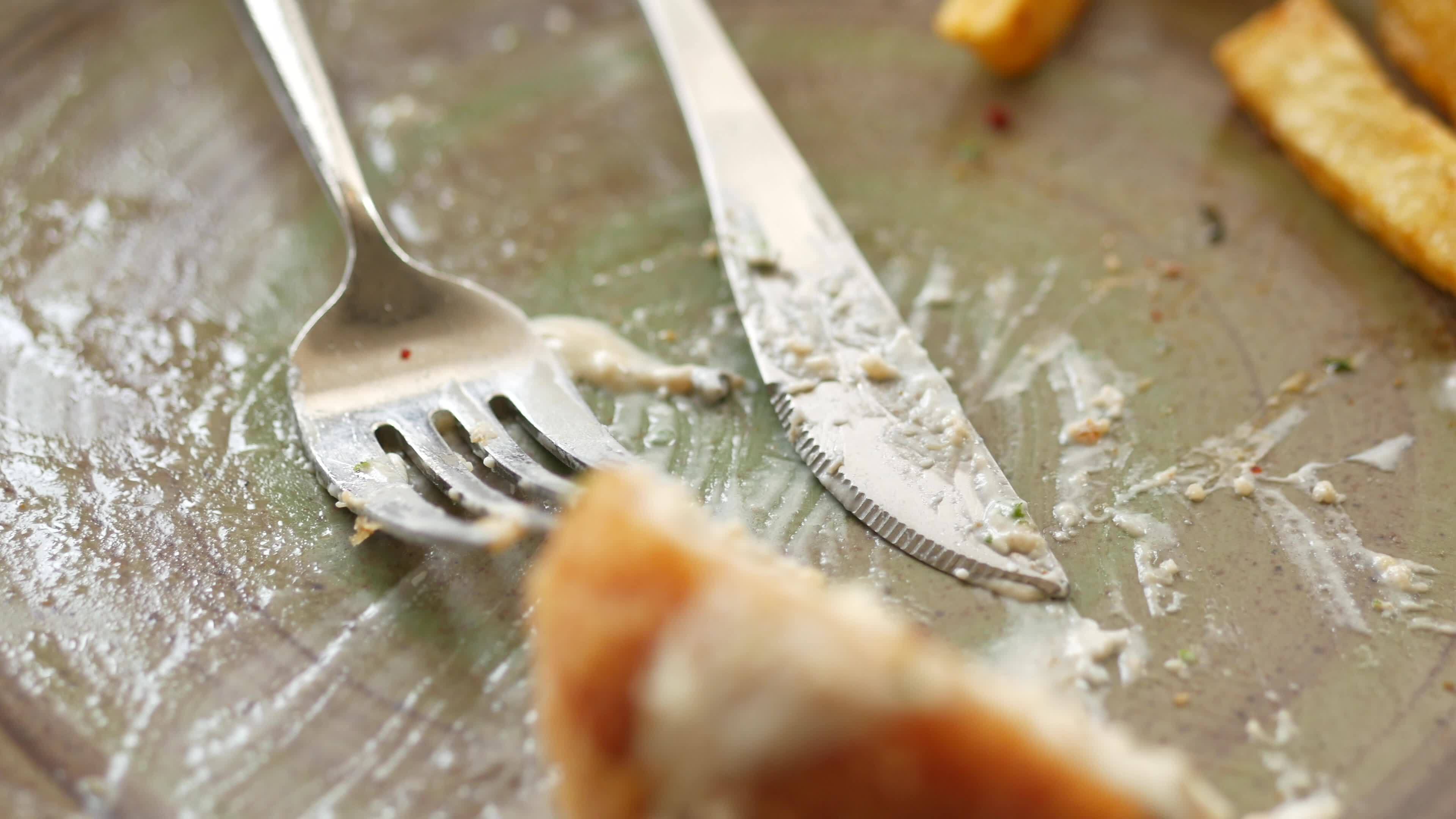 Plate after finishing a meal with fries and sauce fork and knife