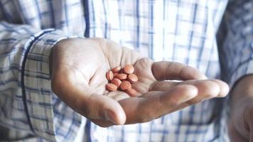 Close up of man holding round pills in palm of hand video