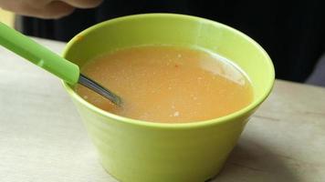 Close up of bowl of soup broth stirred with spoon video