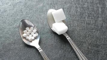 Spoons with sugar cubes and white glucose tablets