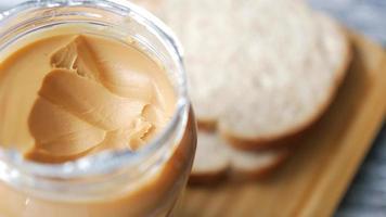 vaso di arachide burro con pane nel sfondo video