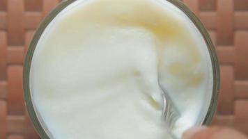 Top down view of spoon stirring a thick creamy liquid