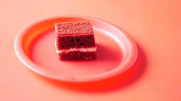 Close up of spoon cutting into a slice of red velvet cake on a pink plate video