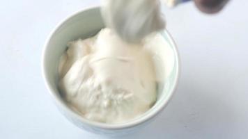 Sour cream or yogurt is poured into a small bowl video