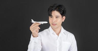 hombre de negocios sosteniendo un avión de juguete blanco limpio que significa viajes aéreos. foto