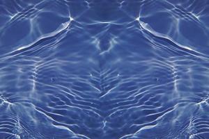 Defocus blurred transparent blue colored clear calm water surface texture with splash, bubble. Shining blue water ripple background. Surface of water in swimming pool. Blue bubble water shining. photo