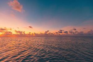 mar tranquilo con cielo de puesta de sol y sol a través de las nubes sobre el océano de meditación y el fondo del cielo. tranquilo paisaje marino. horizonte sobre el agua, naturaleza de relajación pacífica. laguna oceánica, horizonte junto al mar foto