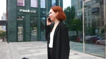 en röd håriga företag kvinna arbetssätt utomhus video