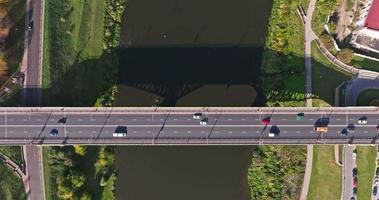 accelerated video with aerial view on heavy traffic on a bridge with a wide multi-lane road across a wide river