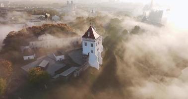 circular flight and aerial panoramic view overlooking the old city and historic buildings of medieval castle near wide river in early morning with fog and mist video