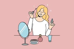 Smiling girl sit at table doing makeup put mascara. Happy young woman look in mirror apply beauty cosmetics products. Daily routine and preparation. Cosmetology. Vector illustration.