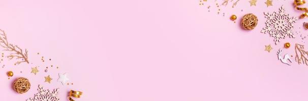 banner de navidad con composición minimalista sobre fondo rosa con decoración dorada y espacio de copia foto