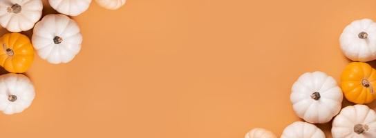 Banner with decorative pumpkins top view on orange background. Autumn flat lay banner photo