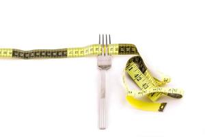 Fork and centimeter tape on a white background, slimming concept photo