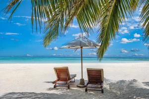 hermosa isla tropical, dos sillas, sombrilla bajo hojas de palmera, cielo de arena de mar paraíso. paisaje de viajes de verano, playa de vacaciones escénica, naturaleza exótica idílica primer plano de recreación, relajación. foto