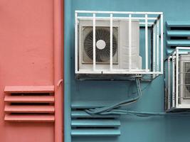 Close-up view of outdoor air cond against blue painted wall photo