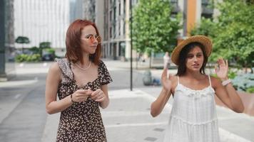 Two women friends meeting up casually on the street video