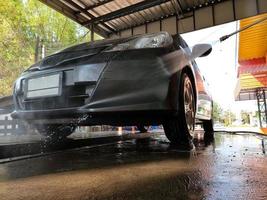 lavado de autos coche de limpieza con agua a alta presión. foto