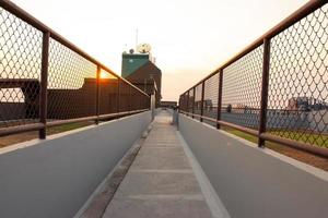 The rooftop walkway has orange sunlight on the sunset sky background photo