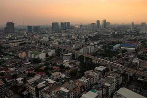 Aerial view of the metropolis at sunset sky, Buildings, roads and electric train routes. photo