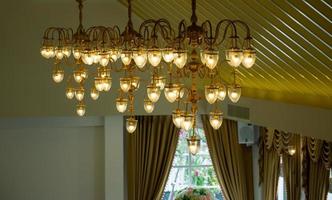 candelabros de luz naranja instalados en el techo del salón de banquetes del hotel. foto