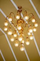 Orange light chandeliers installed on the ceiling of the hotel banquet hall. photo