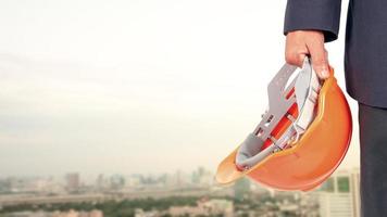 Engineers or architects are carrying a safety hat on the background of a tall building in the city. photo