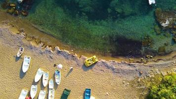 skön vertikal antenn se av blå vågor brytning över en stenig strandlinje på video