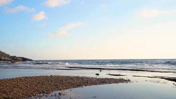 paysage de beauté de la plage de sable blanc et coucher de soleil la formation rocheuse unique et les vagues géantes video