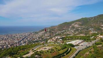 vista superior de alanya en la montaña con bandera de turquía y fondo de la ciudad hermoso paisaje de alanya turquía hito de viaje video