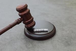 Economy Concept. Law theme. Judge gavel handcuffs and text word economic on grey table. Mallet of judge on concrete stone grey background. Economic crime in business financial crisis stock market. photo