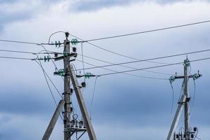 postes de energía de la línea de alto voltaje en el fondo del cielo nublado. foto