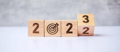 hand flip 2022 to 2023 block with dartboard sign. Business Goal, Target, Resolution, strategy, plan, Action motivation, change, thinking, countdown and New Year start concepts photo