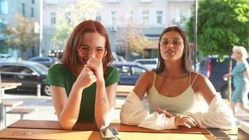 Two women talk and hang out at sunny coffee shop video