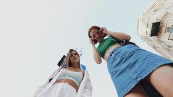 Low shot of 2 girls playing with the camera video