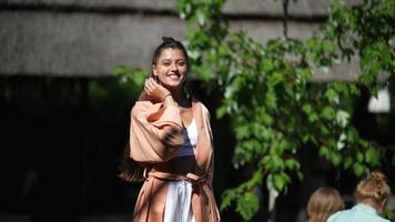 Woman in long flowy robe dances and smiles outside in sunshine video