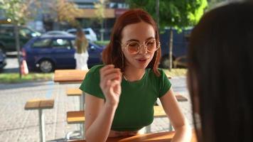 dos mujeres hablan y pasan el rato en una cafetería soleada video