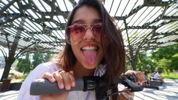 jong vrouw ritten elektrisch scooter Aan een zonnig dag video