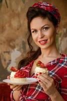 beautiful woman with makeup is holding a cake with strawberries photo