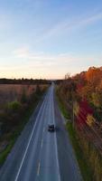 drone suivant voiture pendant à travers les arbres d'automne video