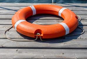 The lifebuoy is lying on a wooden pier. The concept of saving drowning photo