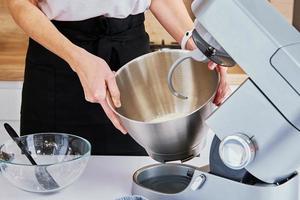 Woman cooking at kitchen and using kitchen machine photo