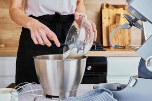 mujer cocinando en la cocina y usando una máquina de cocina foto